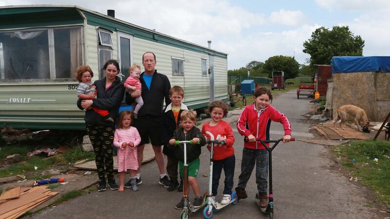Bridget Harty and Johnny Reilly with seven of their nine children, Mikey (18 months), Judy (3), Nelly (6 months), Danny (7), Joe (4), Diane (6) and Biddy (8) beside one of two trailers the family live in on a halting site just off the M8 at Cashel, Co Tipperary. Photograph: Laura Hutton