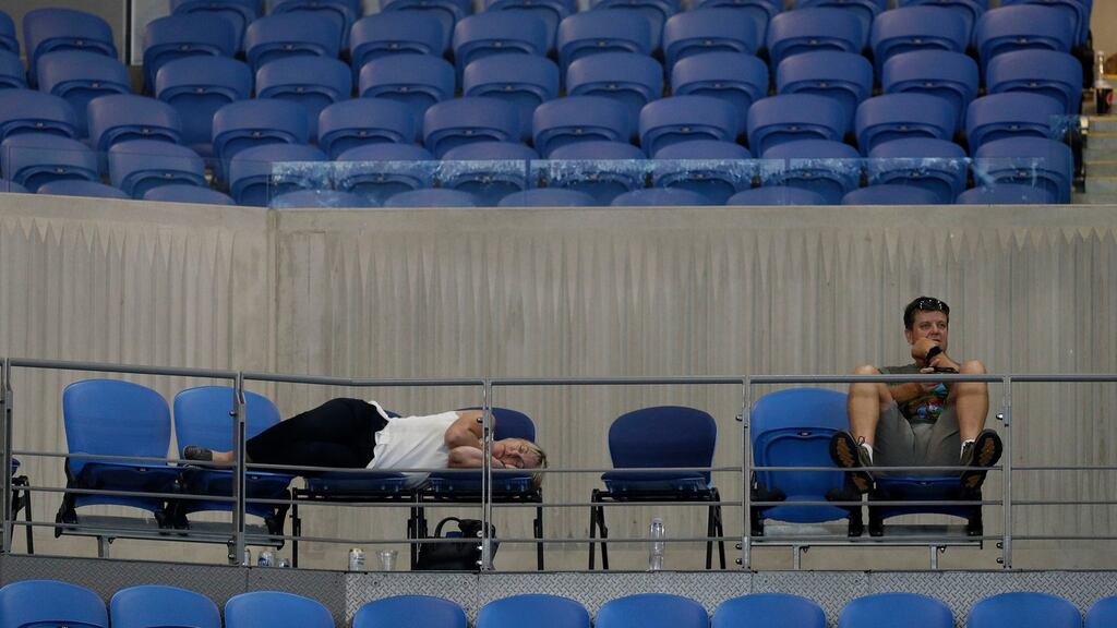 A spectator sleeps at Margaret Court Arena as s Garbine Muguruza and Johanna Konta played their second round match until after 3am at the Australian Open tennis championships in Melbourne. Photograph: Mark Baker/AP