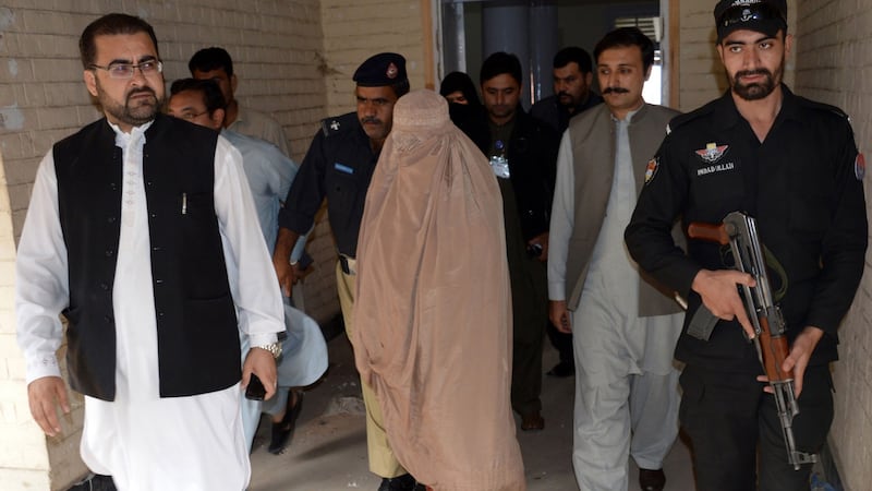 Sharbat Gula (covered), known as the ‘Afghan Girl’ who appeared on the cover of a 1985 edition of National Geographic magazine, leaves the court in Peshawar. Photograph: A Majeeda Majeed/AFP/Getty Images