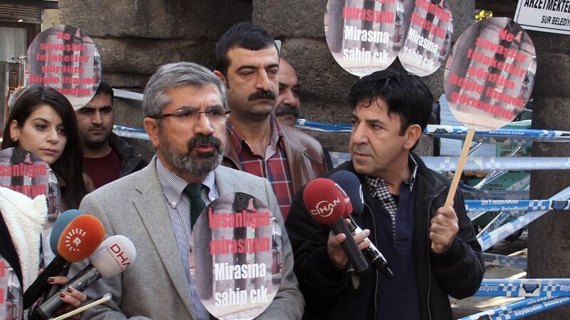Tahir Elci speaks to the media shortly before being shot and killed in Diyarbakir, Turkey. He holds a placard that reads: “Let’s protect humanity heritage.” Photograph: Ilyas Akengin/AP