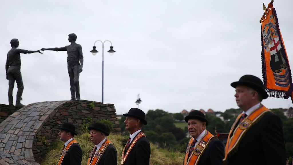 An Orange Order parade passes the Hands Across the Divide statue in Derry. Photograph: Brian Lawless/PA Wire