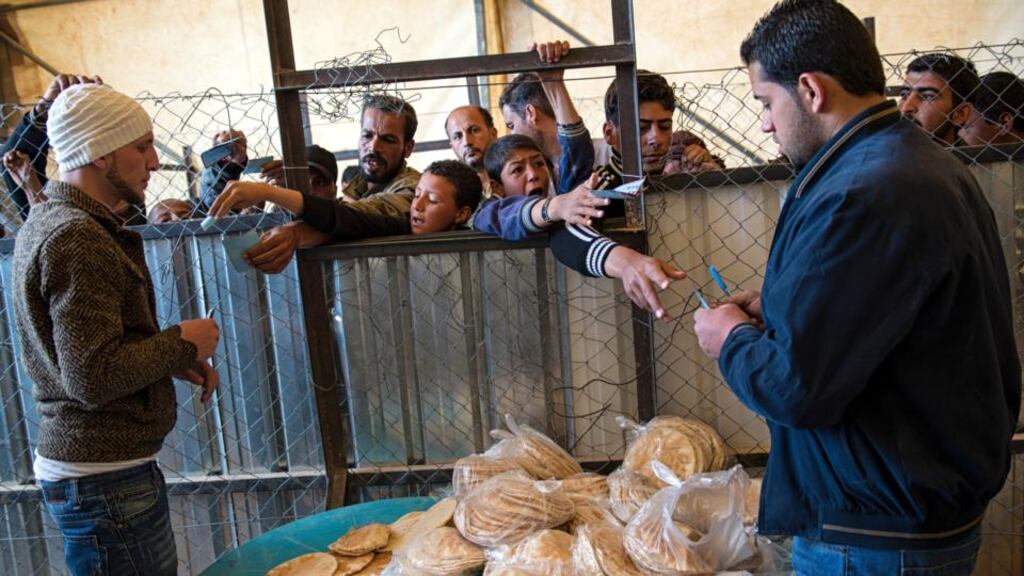 Syrian refugees wait in line for a daily bread ration distributed by the World Food Program at the Zaatari refugee camp in Jordan. Photograph: Lynsey Addario/The New York Times