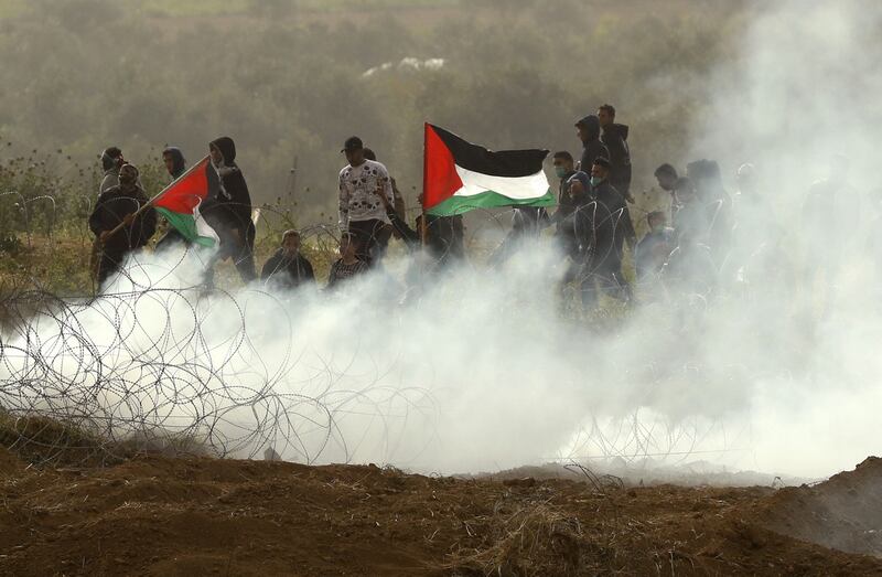 Palestinian protesters wave national flags as they demonstrate on the Gaza Strip. Photograph: Jack Guez/AFP/Getty