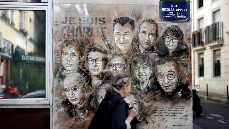 A woman walks past a painting by French street artist and painter Christian Guemy, known as C215, in tribute to staff of the Charlie Hebdo newspaper who were killed in the January 2015 assault, in Paris on August 31st, 2020. Photograph: Thomas Coex/AFP/Getty