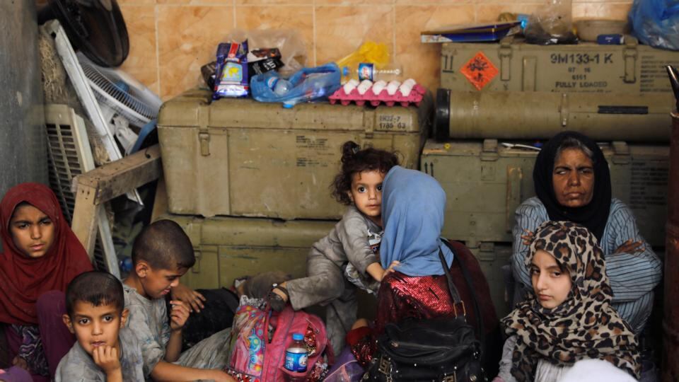 Displaced Iraqi civilians rescued at the site of battle rest at the positions of Iraqi forces at the Old City in Mosul. Photograph: Goran Tomasevic/Reuters