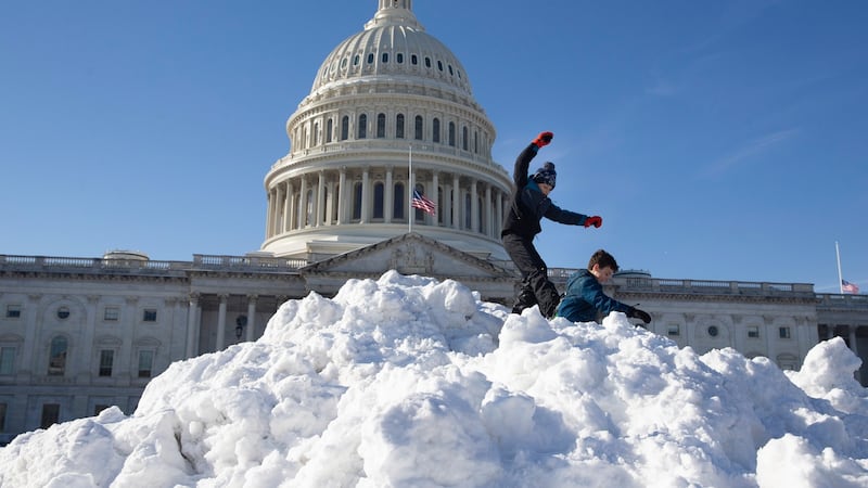 Kids play on top of a large pile of snow near the Capitol in Washington. Photograph: Michael Reynolds/EPA