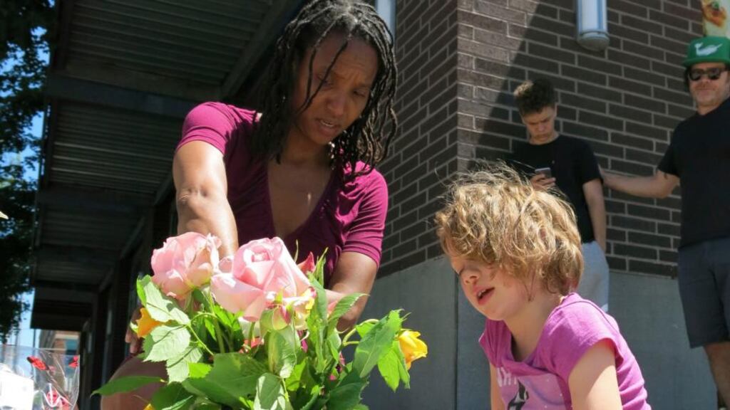 Portland murders: Angel Sauls helps her stepdaughter, Coco Douglas, arrange a memorial to Taliesin Myrddin Namkai-Meche and Rick Best. Photograph: Gillian Flaccus/AP