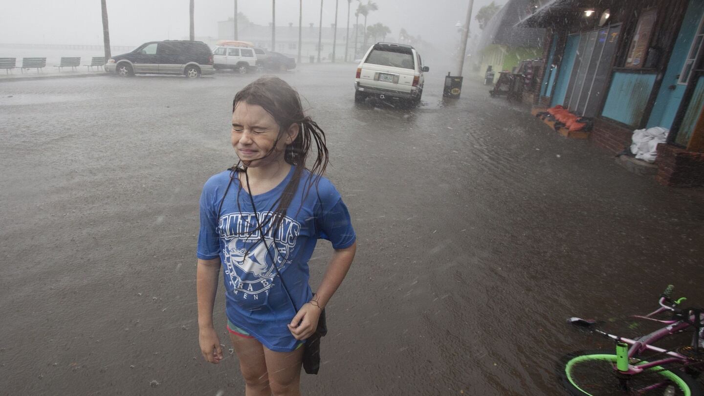 Hannah Coles (9) takes a break from riding her bike to feel a strong rain band rain in Gulfport, Florida. Photograph: John Pendygraft/Tampa Bay Times via AP