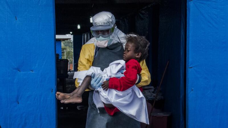 Crisis: a doctor carries a nine-year-old Ebola patient in Liberia. Photograph: Daniel Berehulak/New York Times