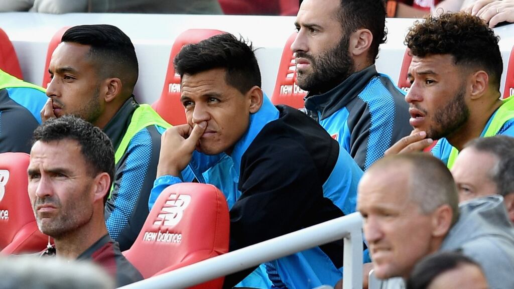 Alexis Sanchez of Arsenal looks on from the bench during the Premier League loss to Liverpool at Anfield. Photo: Michael Regan/Getty Images