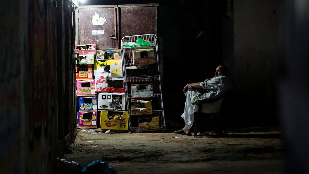 A Palestinian  sits outside his shop on Tuesday this week during the few hours of mains electricity the residents of the Gaza Strip enjoy every day. Photograph: Mahmud Hams/AFP/Getty Images