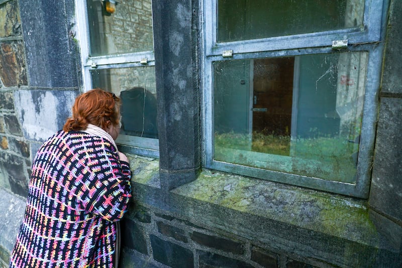 Catherine Coffey O'Brien peers into St Finan's hospital, which has been closed since 2012. Photograph: Enda O'Dowd