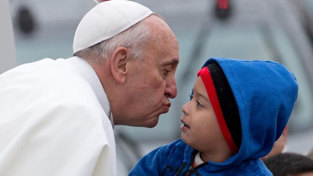 Pope Francis reaches out to kiss a child as he arrives at the Aparecida basilicia in Brazil yesterday. Photograph: AP Photo/Domenico Stinellis