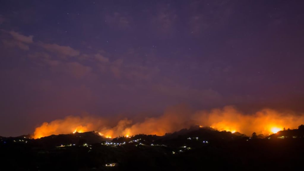 Flames and smoke from a forest fire are seen in the village of Moya, on the Canary Island of Gran Canaria on Sunday. Photograph: Borja Suarez/Reuters