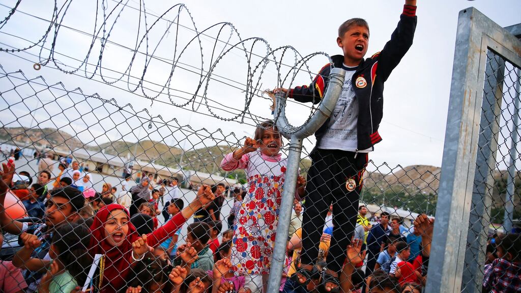 Refugee youths gesture from behind a fence at Nizip refugee camp near Gaziantep, Turkey, April 23rd, 2016. Photograph: Umit Bektas/File/Reuters