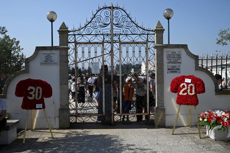 Wreath in shape of football jerseys are displayed at the entrance of the cemetery after the funeral ceremony. Photograph: Miguel Riopa/AFP/Getty