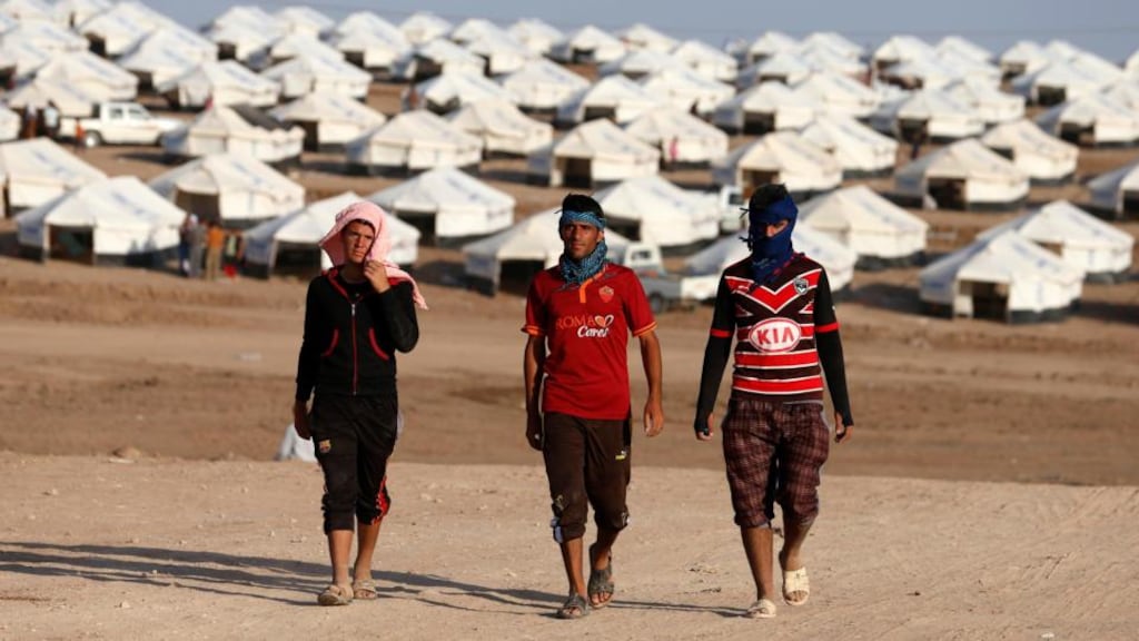 Displaced people from the minority Yazidi sect, who fled the violence in the Iraqi town of Sinjar, walk in Bajed Kadal refugee camp south west of Dohuk province. Photograph: Youssef Boudlal/Reuters