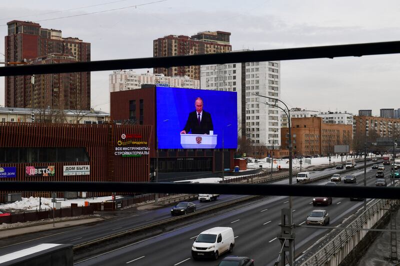 Vehicles drive past a screen in Moscow displaying Russian president Vladimir Putin's annual state of the nation address. Photograph: Olga Maltseva/AFP via Getty Images