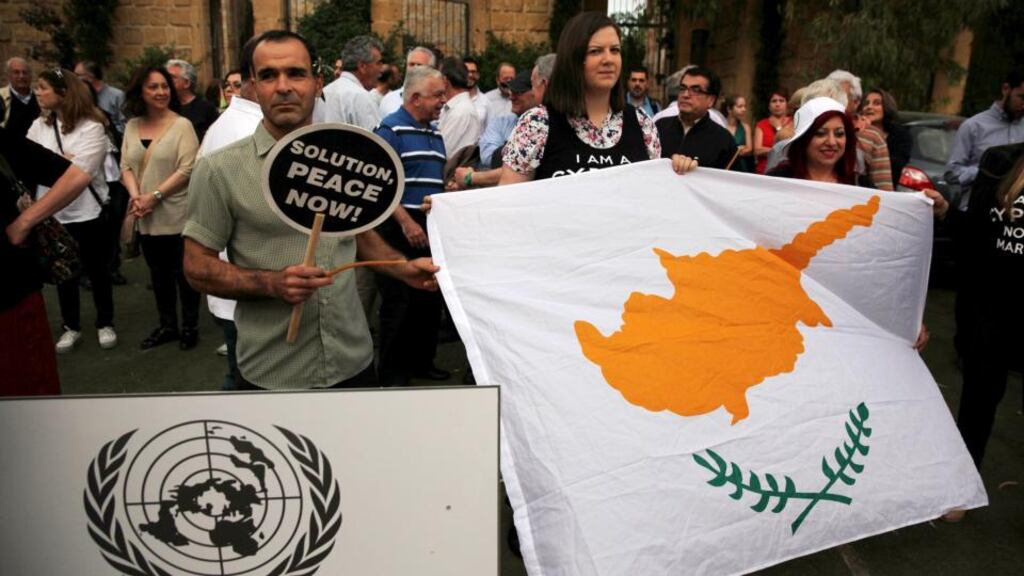 Women hold a Cyprus flag during a demonstration in favour of a peace settlement on divided Cyprus. It was the first encounter of Greek Cypriot leader Nicos Anastasiades and Turkish Cypriot leader Mustafa Akinci since Akinci, a leftist moderate, won leadership elections in northern Cyprus on April 26th. Photograph: Yiannis Kourtoglou/Reuters