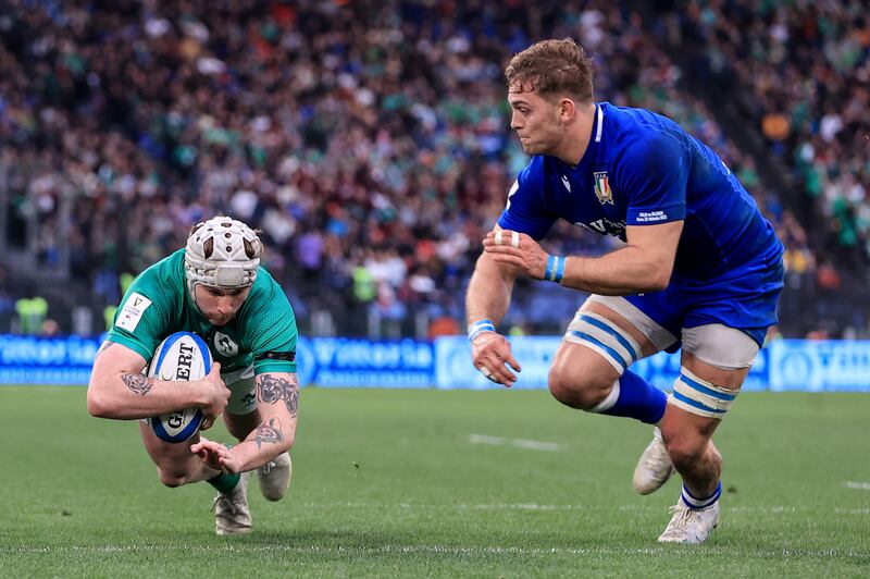 Mack Hansen scores Ireland's fourth try despite the efforts of Italy's Edoardo Padovani at the Stadio Olimpico in Rome. Photograph: Dan Sheridan/Inpho