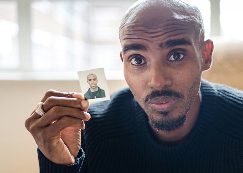 Mo Farah holding up a picture of himself as a child during the filming of the BBC documentary, The Real Mo Farah. Photograph: Andy Boag/BBC/PA Wire