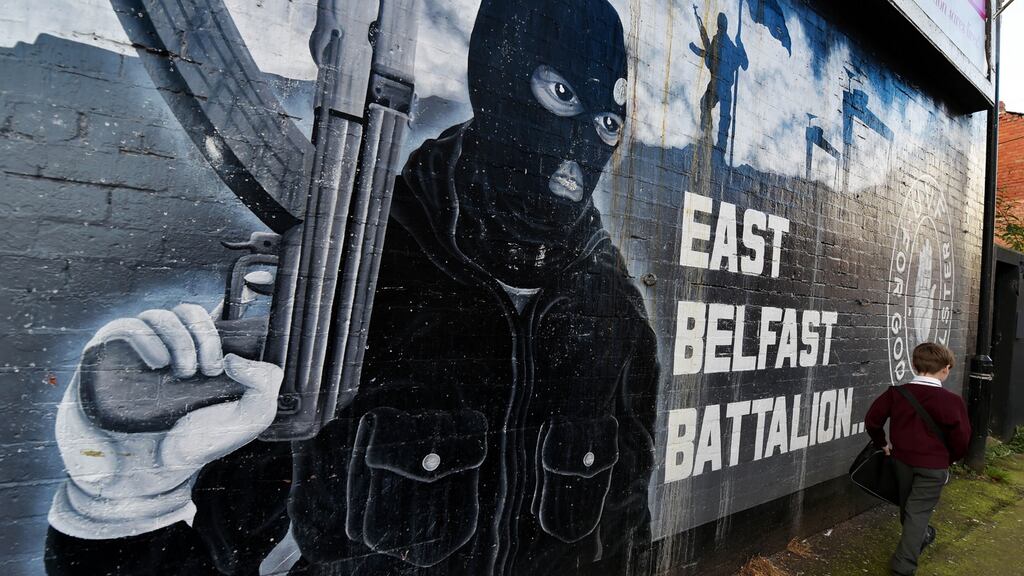 A young boy walks past a loyalist paramilitary mural  in Belfast, Northern Ireland. Photograph: Charles McQuillan/Getty Images