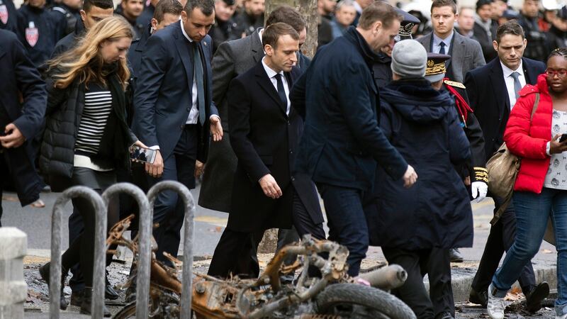 French president Emmanuel Macron (centre) on Sunday assesses the damage from the ‘yellow vests’ protests next to the Champs Elysee in Paris. Photograph: EPA