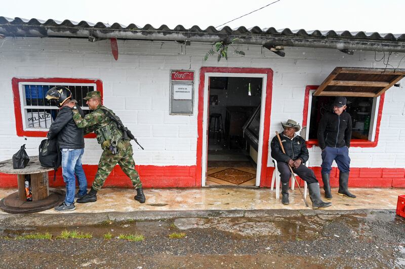 A soldier searches a man at a checkpoint on a road near Yarumal, Antioquiat, Colombia, in May 2022. Photograph: Joaquin Sarmiento /AFP via Getty Images