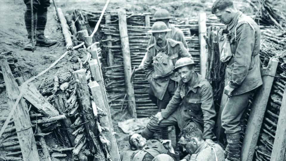 Irish Guards with a wounded man in a trench near Wytschaete, Belgium. Photograph: From Father Browne’s First World War by E E O’Donnell (Messenger Publications)