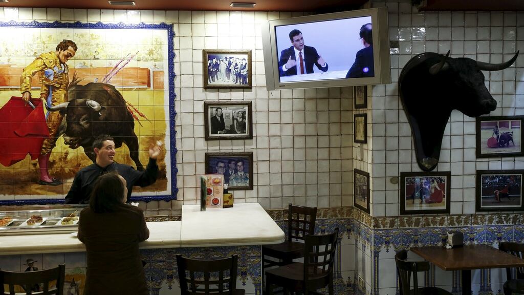 A waiter and a patron chat as they look at a television debate between Spain’s prime minister Mariano Rajoy and opposition leader Pedro Sanchez during at a restaurant in Madrid on Monday. Photograph: Susana Vera/Reuters