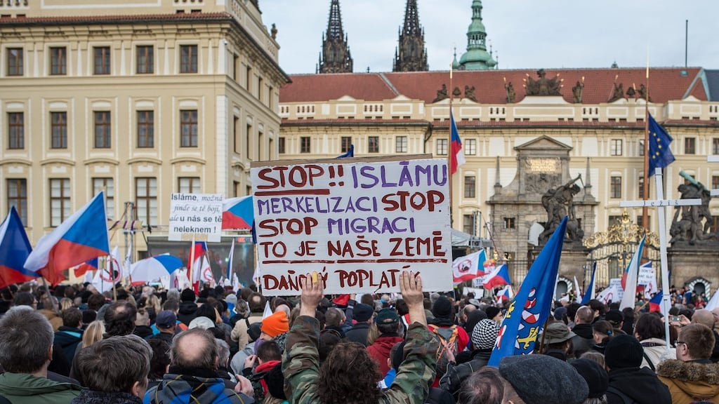 A protester holds a sign reading in Czech “Stop Islam and stop Merkel”, during an anti-Islam rally in front of Prague Castle. Photograph: Filip Singer/EPA