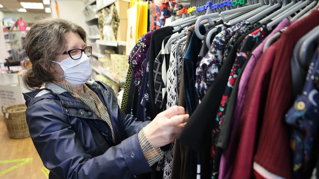 A woman shopping in a charity shop in Derry. Northern Ireland’s Minister for Finance, Conor Murphy, announced a £350,000 scheme to support hospitality businesses in the Derry and Strabane area, where greater Covid restrictions apply. Photograph: Liam McBurney/PA Wire