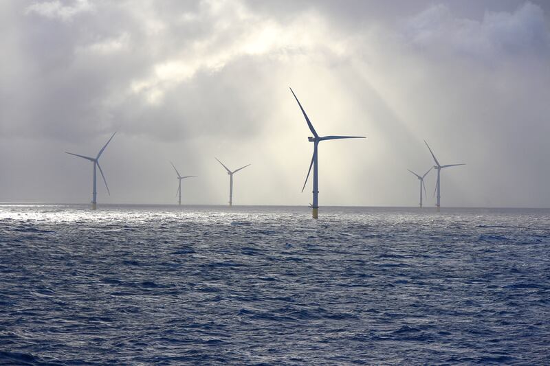 Rays of sun light up offshore wind-farm turbines. Stock image. Photograph: iStock