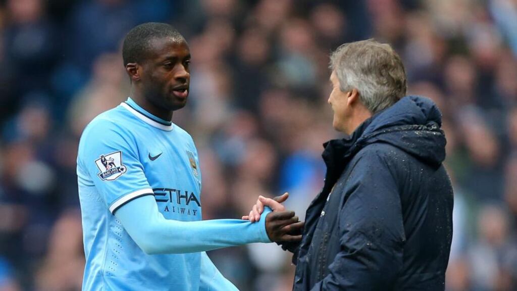 Manchester City’s Yaya Toure and manager Manuel Pellegrini. Pellegrini is convinced the player is fully committed to the champions despite more mixed messages from the midfielder. Photo: Dave Thompson/PA