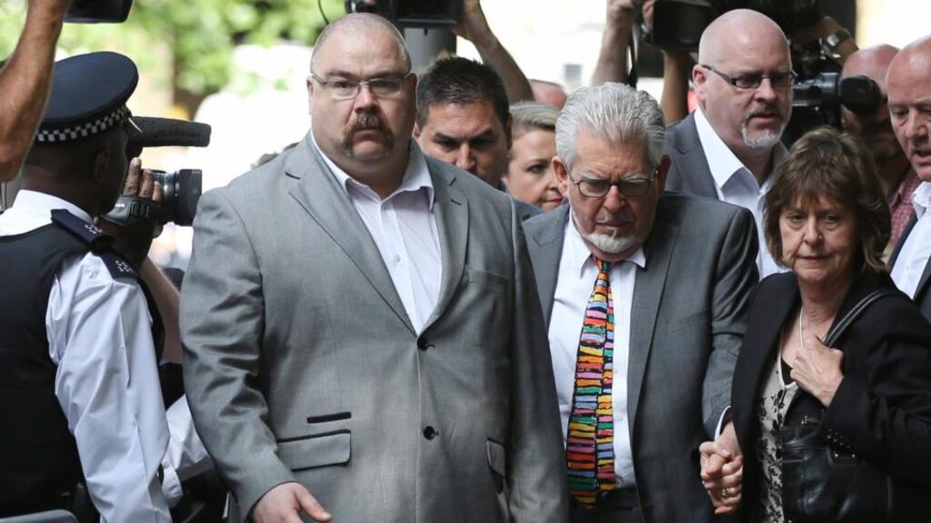 Entertainer Rolf Harris (2nd R) walks with his niece Jenny (R) as he arrives for sentencing at Southwark Crown Court in London today. The entertainer will not face a trial over allegations he downloaded sexual images of children. Photograph: Paul Hackett/Reuters.