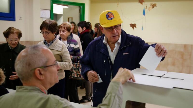 A man bearing a hat with a pro-Catalan independence flag casts his ballot in a symbolic independence vote in Barcelona today. Photograph: Paul Hanna/Reuters