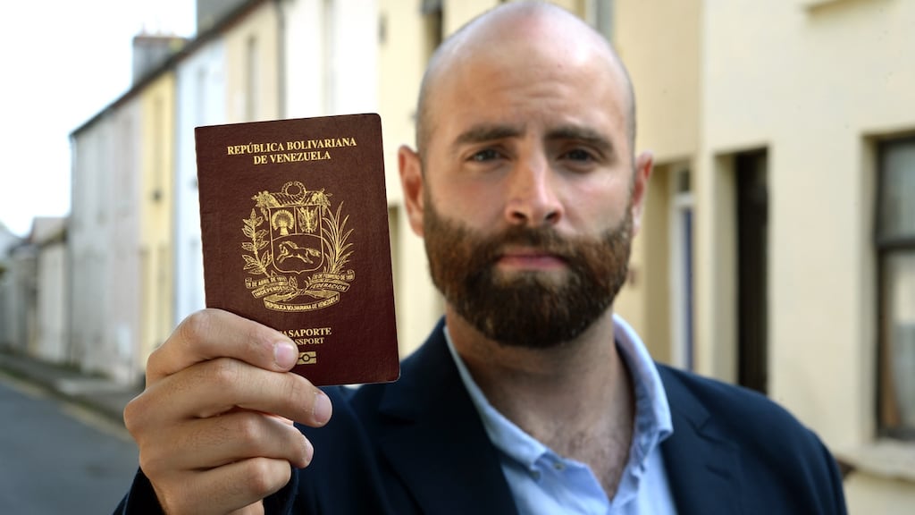 Juan Ayala, with his Venezuelan passport which is due to expire soon, pictured in Drumcondra, Dublin. Photograph: Dara Mac Dónaill