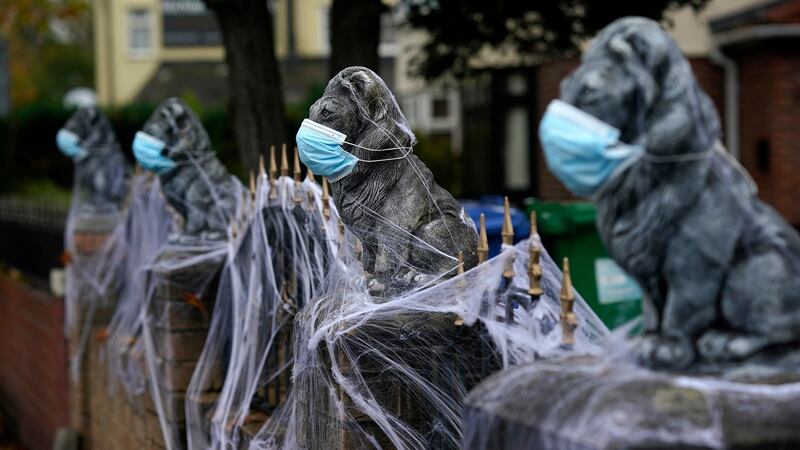 A home in Warrington, England is decorated for Halloween with face masks and synthetic cobwebs as the borough enters Covid-19 Tier 3 ‘Very High’ lockdown restrictions on Tuesday. Photograph: Christopher Furlong/Getty Images