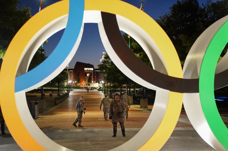 Members of the Georgia National Guard are seen through the Olympic rings in Atlanta. Photograph: Elijah Nouvelage