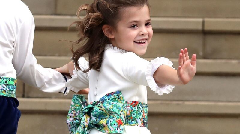 A bridesmaid waves a she arrives for the wedding of Princess Eugenie to Jack Brooksbank. Photograph: PA