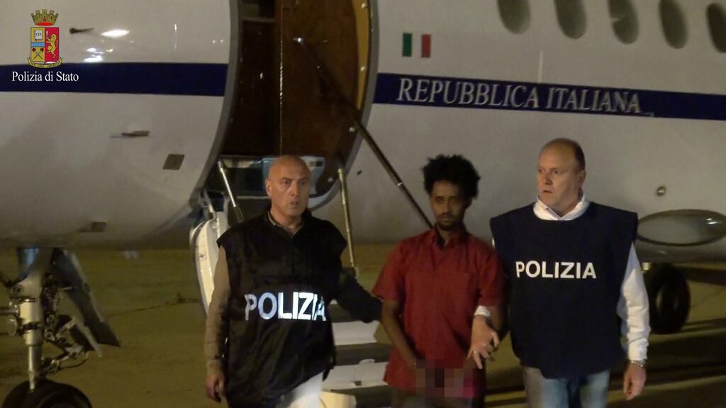 A man presented as Medhanie Yehdego Mered (35) an Eritrean suspected of controlling a migrant trafficking network, is escorted by policemen upon his extradition from Sudan to Italy on June 6th. The man says he is the victim of mistaken identity. Photograph: AFP/Italian police
