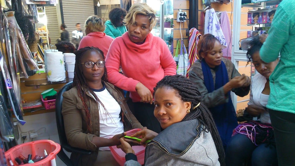 Suzanne Niamke (left) at work in her busy beauty salon.