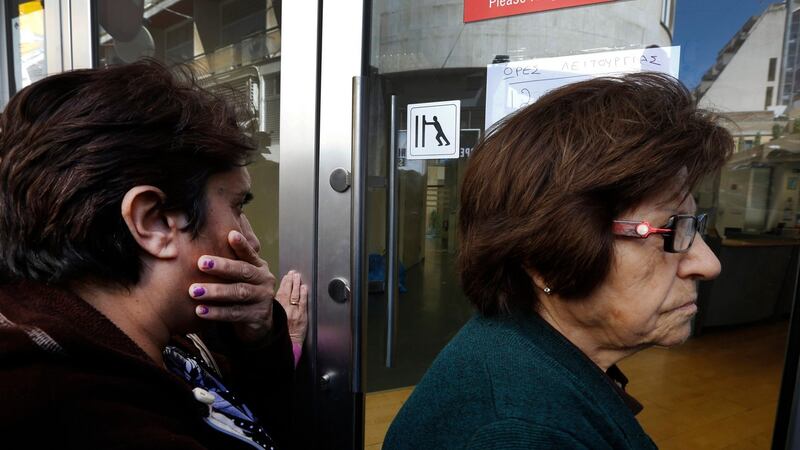 Depositors wait outside a Laiki Bank branch shortly before it opened in Nicosia this morning. Photograph: Reuters