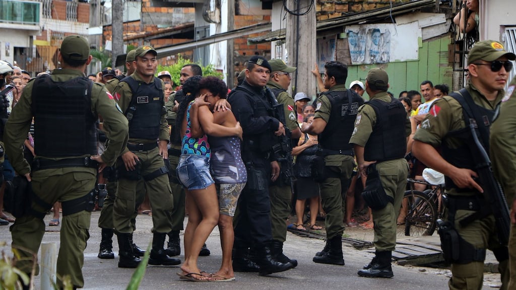 Residents mourn surrounded by police officers outside a bar after a shooting, in Belém, Para state, Brazil. Photograph: Claudio Pinheiro/Agencia Panamazonica/AFP/Getty Images