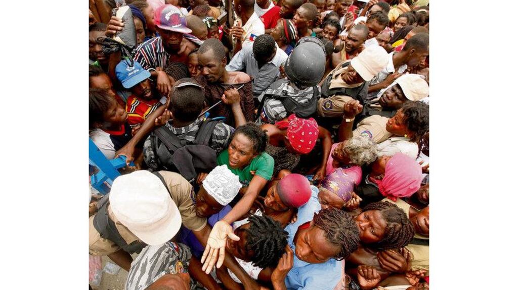 Haitians swarm around the gates at a food distribution point in the Cite Soleil slum yesterday. A huge international relief operation is struggling to feed, house and care for hundreds of thousands of hungry, homeless survivors, many injured. Photograph: Gerald Herbert/AP