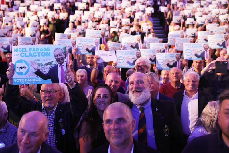 Supporters wave banners as Reform Party leader Nigel Farage speaks at a 'Meet Nigel Farage' event in Clacton-on-Sea Photograph: EPA