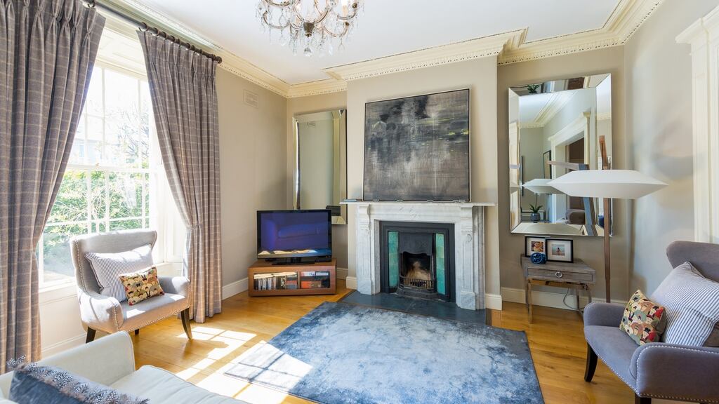 The two interconnecting reception rooms have matching marble fireplaces with duck-egg blue tile inserts, shuttered sash windows, cornicing and ceiling roses