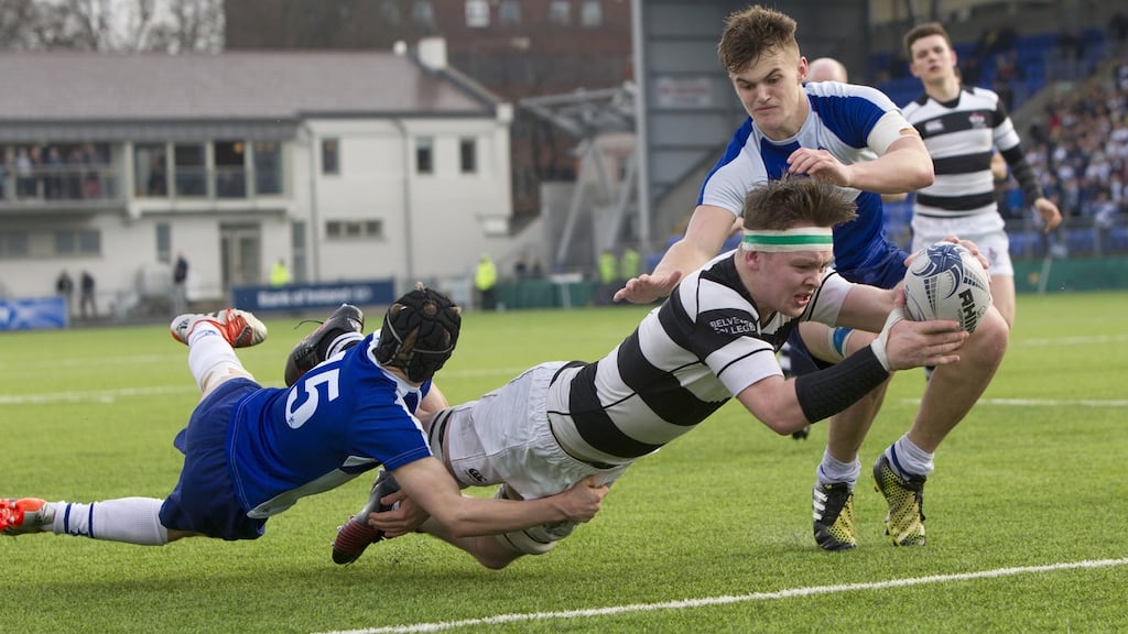 Belvedere’s Ruadhan Byron goes over for a try despite the tackle of Andrew Vincent. Photograph: Inpho