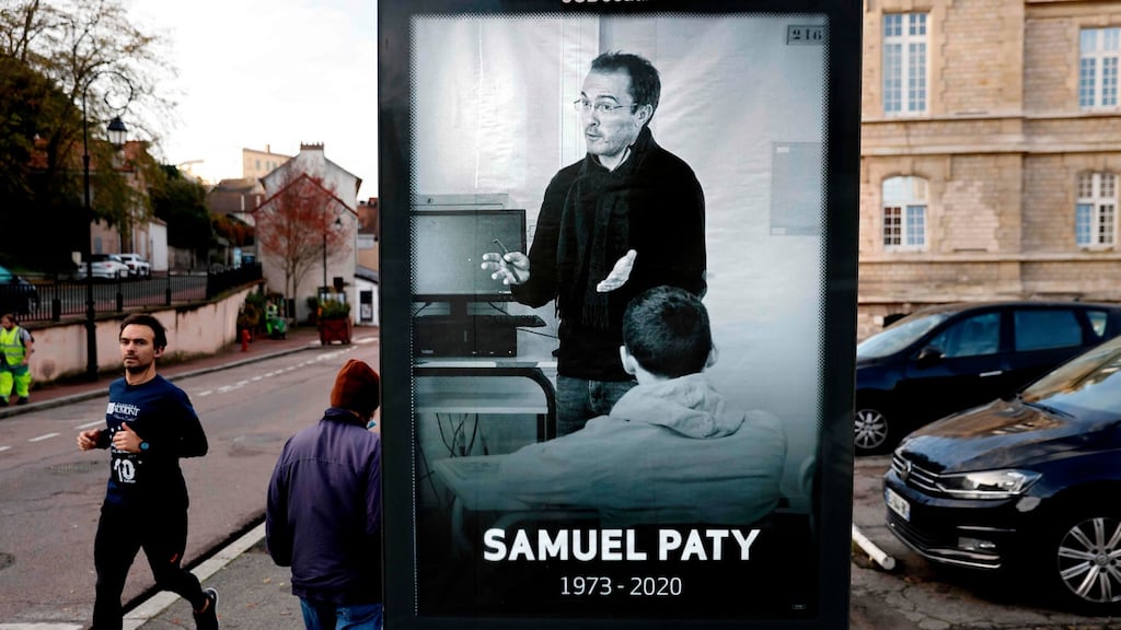 Pedestrians pass a poster depicting French teacher Samuel Paty placed in Conflans-Sainte-Honorine, 30kms northwest of Paris following the decapitation of the teacher. Photograph: Thomas Coex/Getty Images
