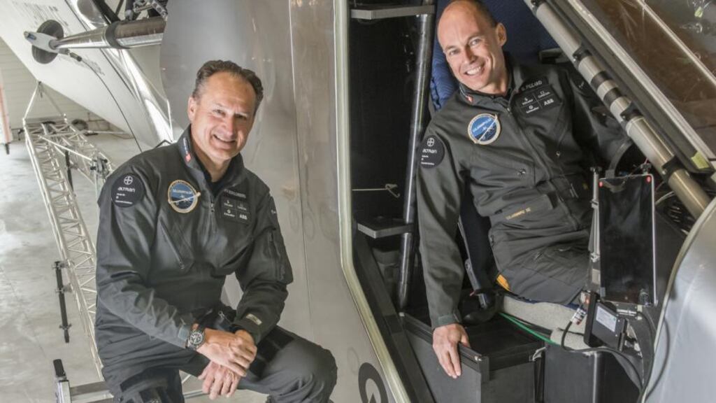 André Borschberg, Co-founder and CEO and Bertrand Piccard, Initiator and Chairman (in the cockpit) standing beside the cockpit of Solar Impulse 2, the single seater solar airplane with which they will attempt the first round-the-world solar flight. Photograph: Jean Revillard/Rezo.ch